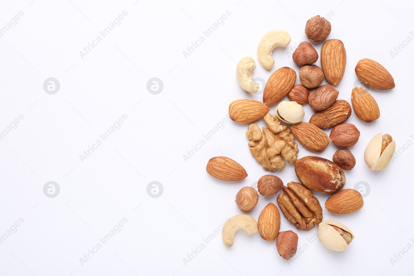 Photo of Mix of different nuts on white background, flat lay. Space for text