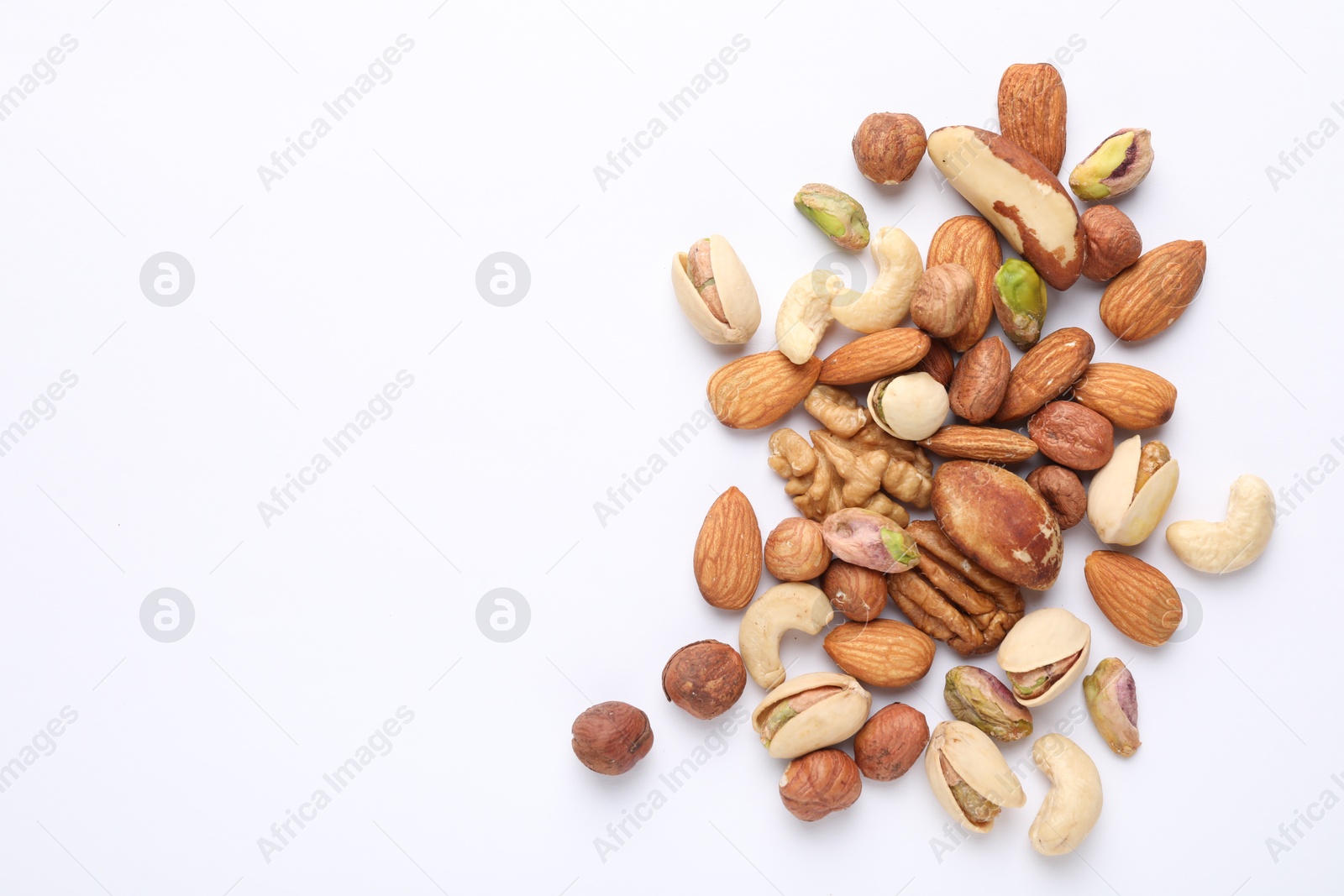 Photo of Mix of different nuts on white background, flat lay. Space for text