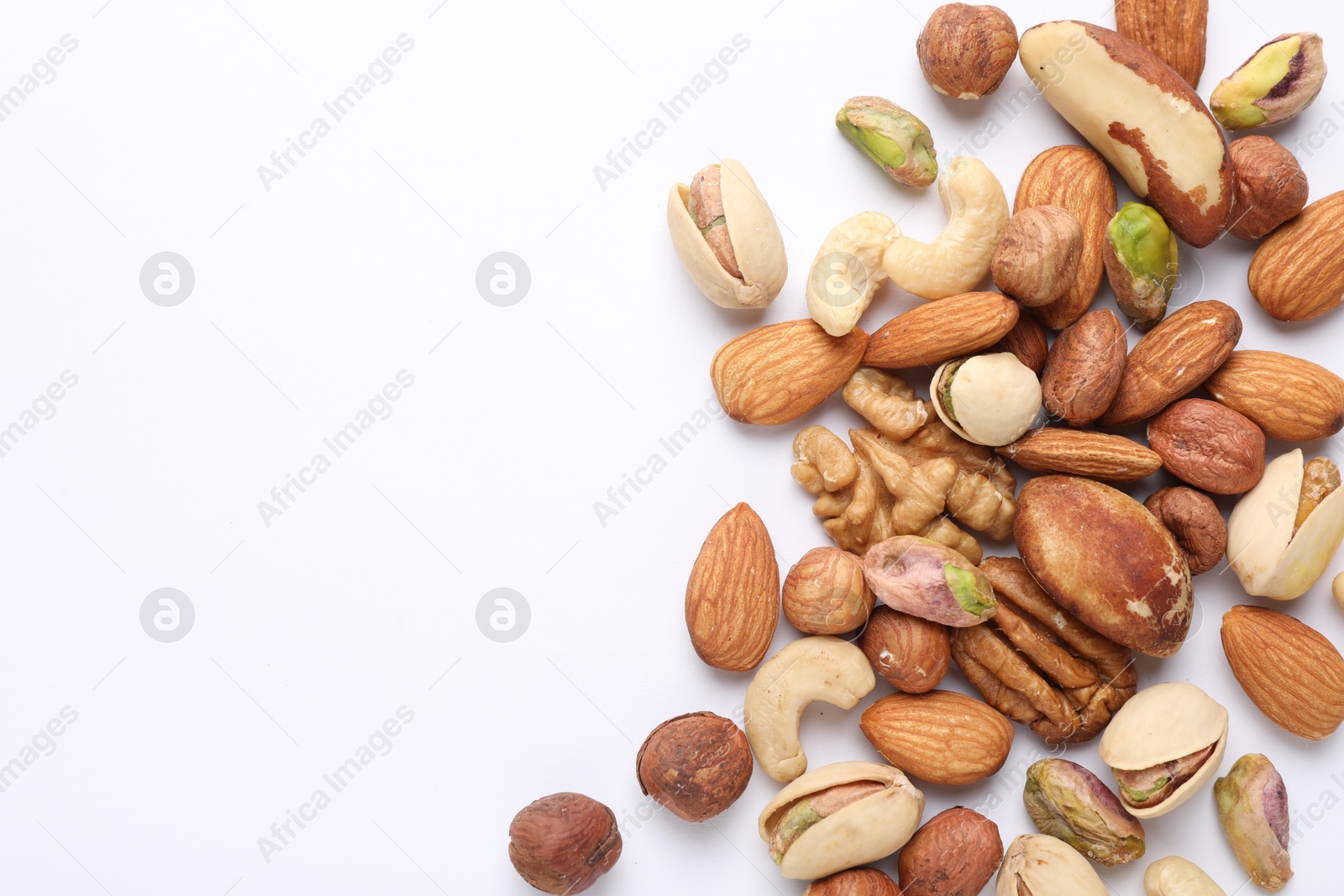 Photo of Mix of different nuts on white background, flat lay. Space for text