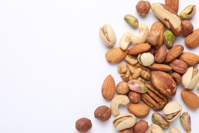 Photo of Mix of different nuts on white background, flat lay. Space for text