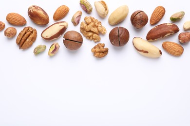 Photo of Mix of different nuts on white background, flat lay. Space for text