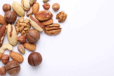 Photo of Mix of different nuts on white background, flat lay. Space for text