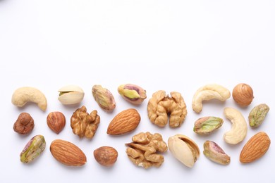 Photo of Mix of different nuts on white background, flat lay. Space for text