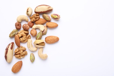Photo of Mix of different nuts on white background, flat lay. Space for text