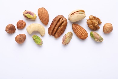 Photo of Mix of different nuts on white background, flat lay. Space for text