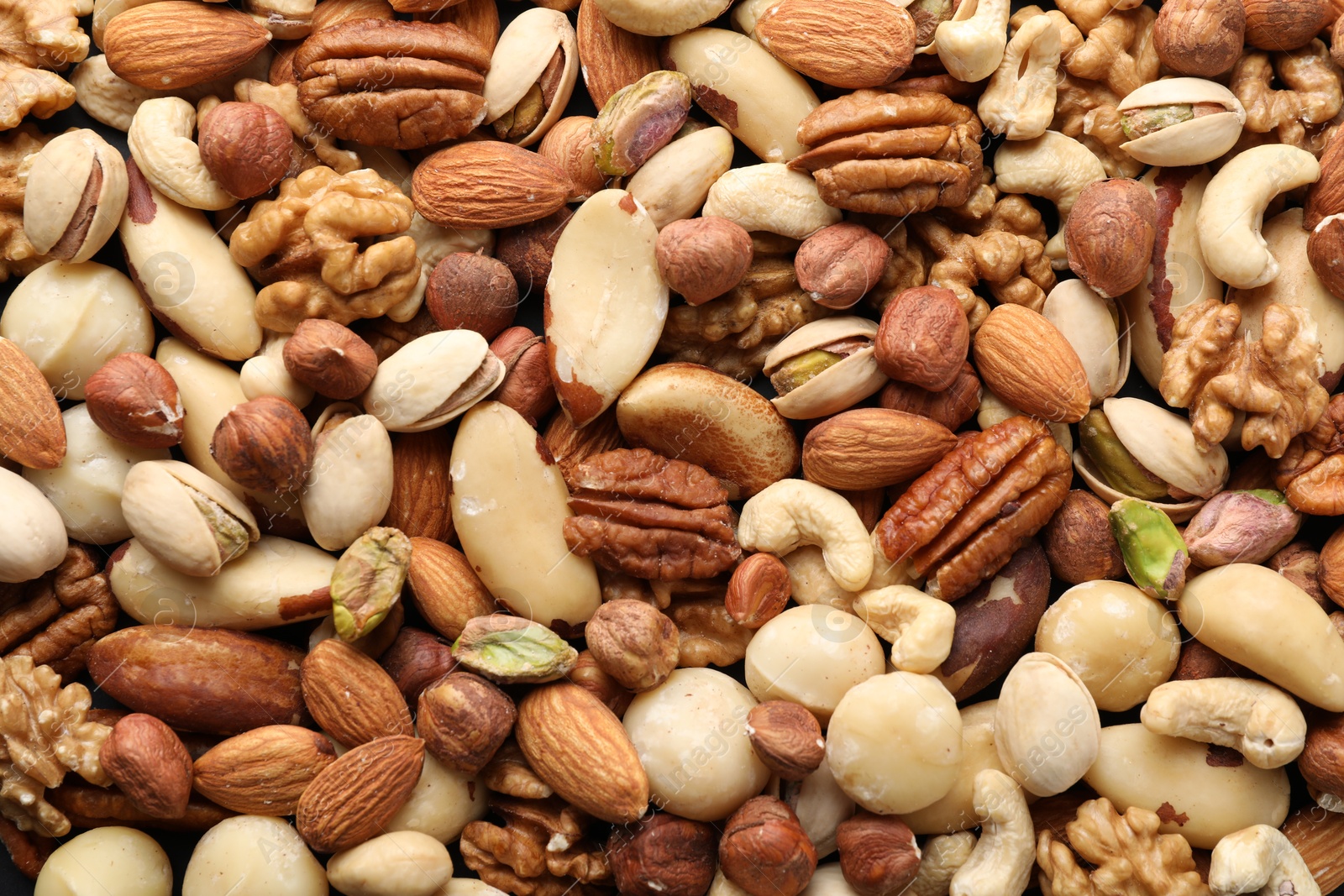 Photo of Mix of different nuts as background, closeup