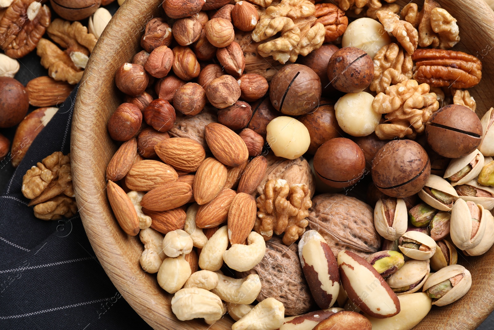 Photo of Mix of different nuts in bowl on table, top view