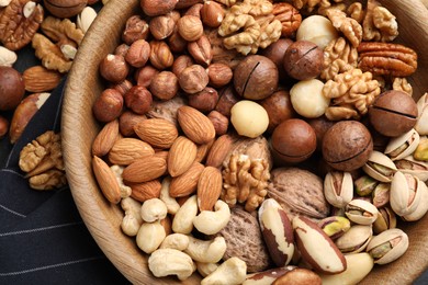 Photo of Mix of different nuts in bowl on table, top view