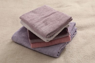 Photo of Stack of terry towels on beige blanket, closeup