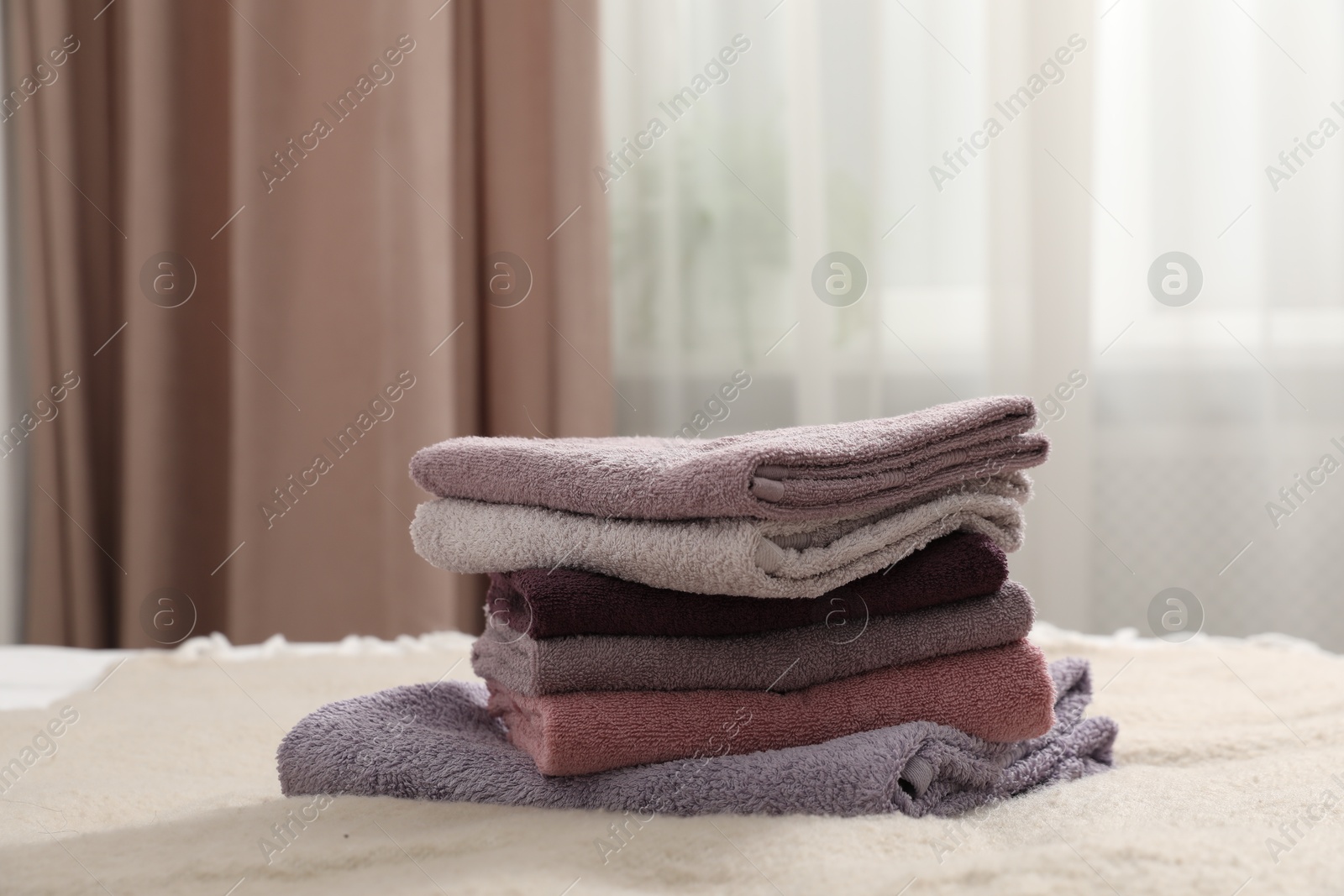 Photo of Stack of terry towels on bed indoors, closeup