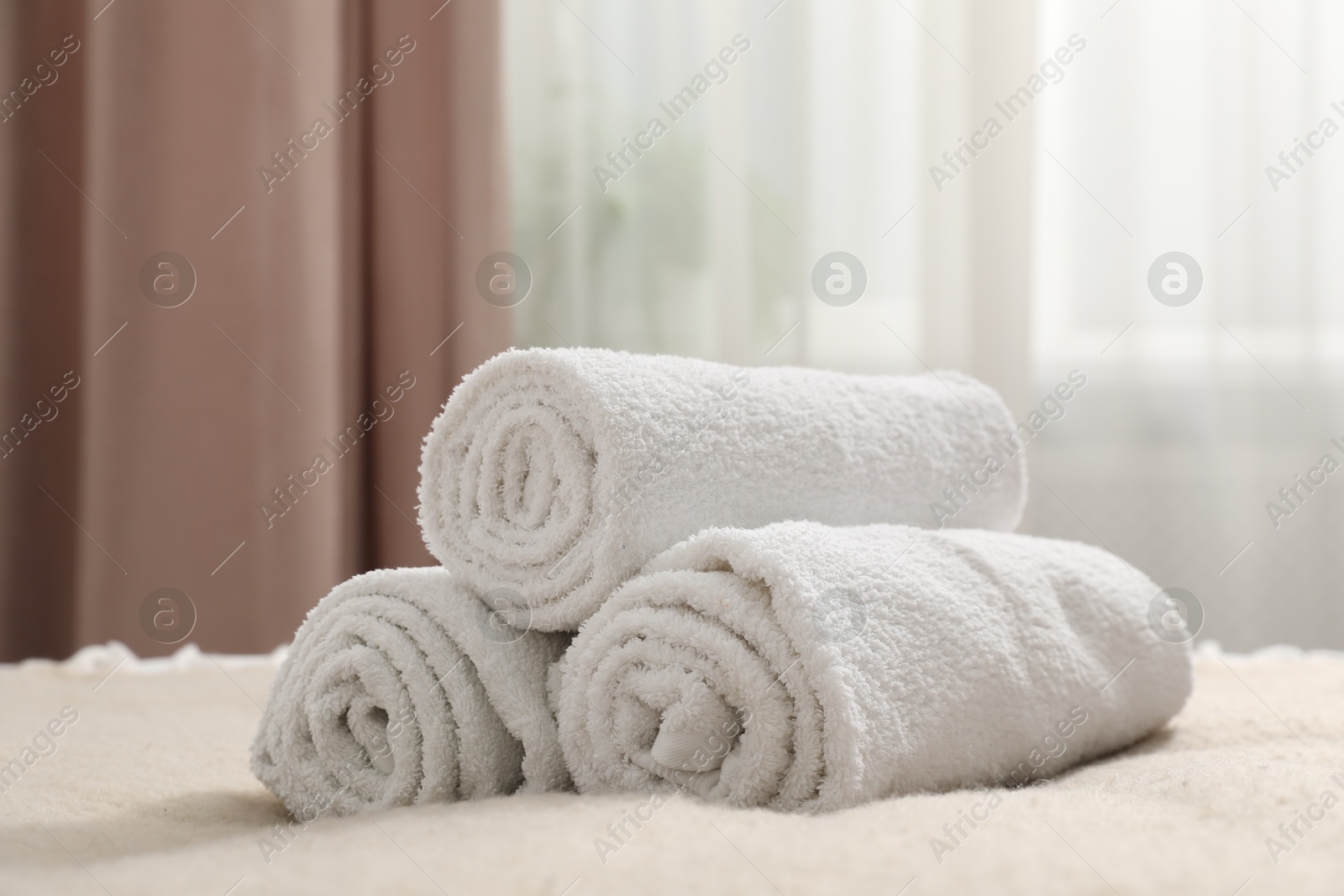 Photo of Rolled white towels on bed indoors, closeup