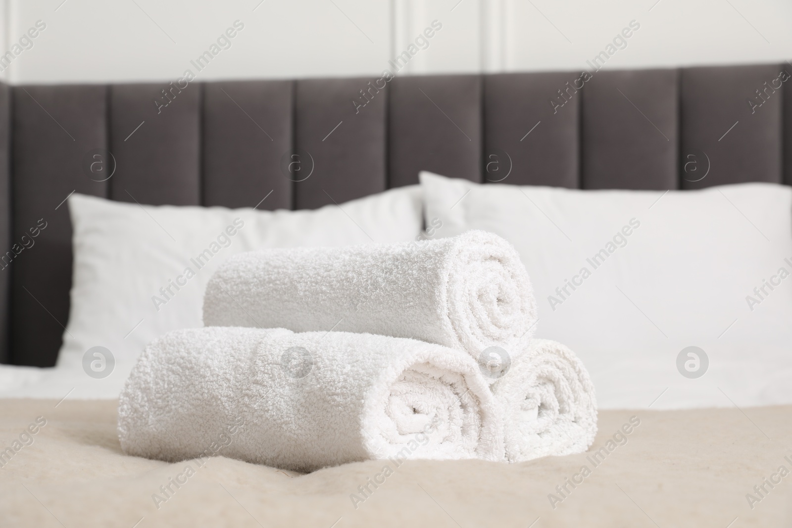 Photo of Rolled white towels on bed indoors, closeup