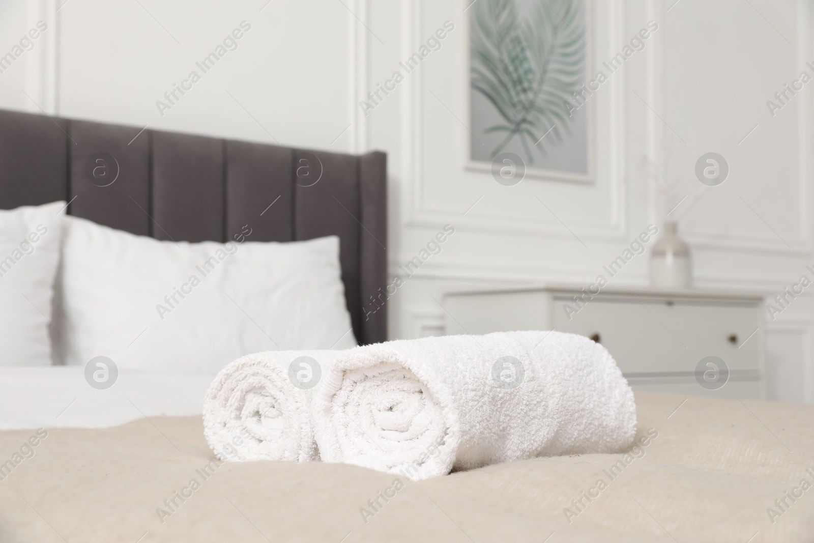 Photo of Rolled white towels on bed indoors, closeup