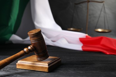 Photo of Judge's gavel, flag of Italy and scales on black wooden table, closeup. Space for text