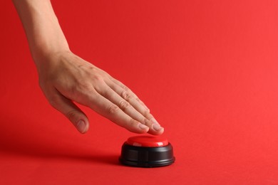 Photo of Woman pressing button on red background, closeup