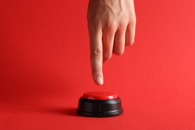 Photo of Woman pressing button on red background, closeup