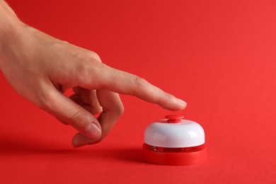Photo of Woman pressing button on red background, closeup