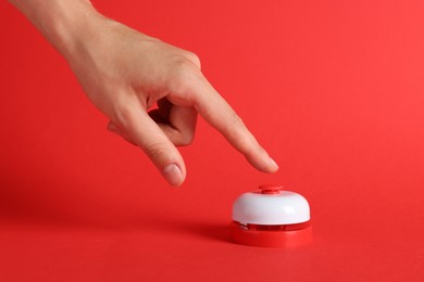 Photo of Woman pressing button on red background, closeup