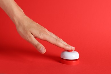 Photo of Woman pressing button on red background, closeup