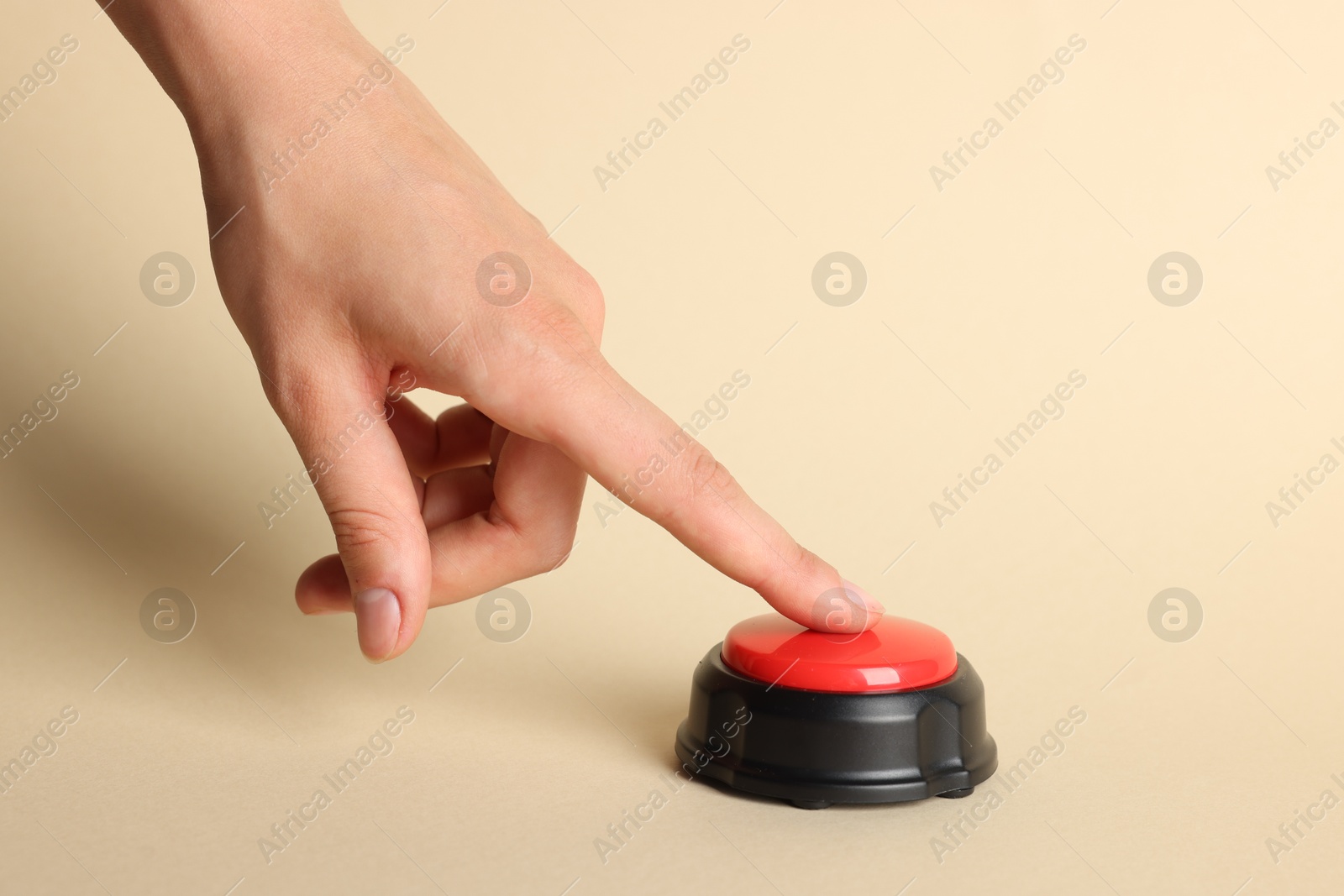 Photo of Woman pressing red button on beige background, closeup