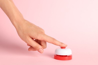 Photo of Woman pressing red button on pink background, closeup