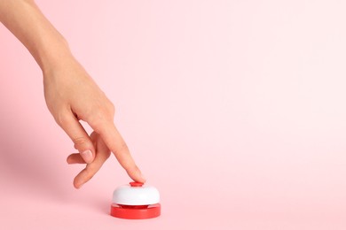 Photo of Woman pressing red button on pink background, closeup. Space for text