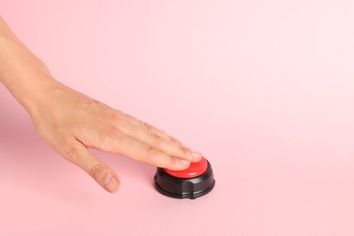 Photo of Woman pressing red button on pink background, closeup. Space for text