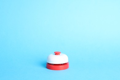 Photo of One red button on light blue background, space for text