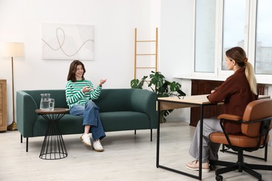 Photo of Professional psychologist working with teenage girl in office