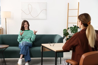 Photo of Professional psychologist working with teenage girl in office