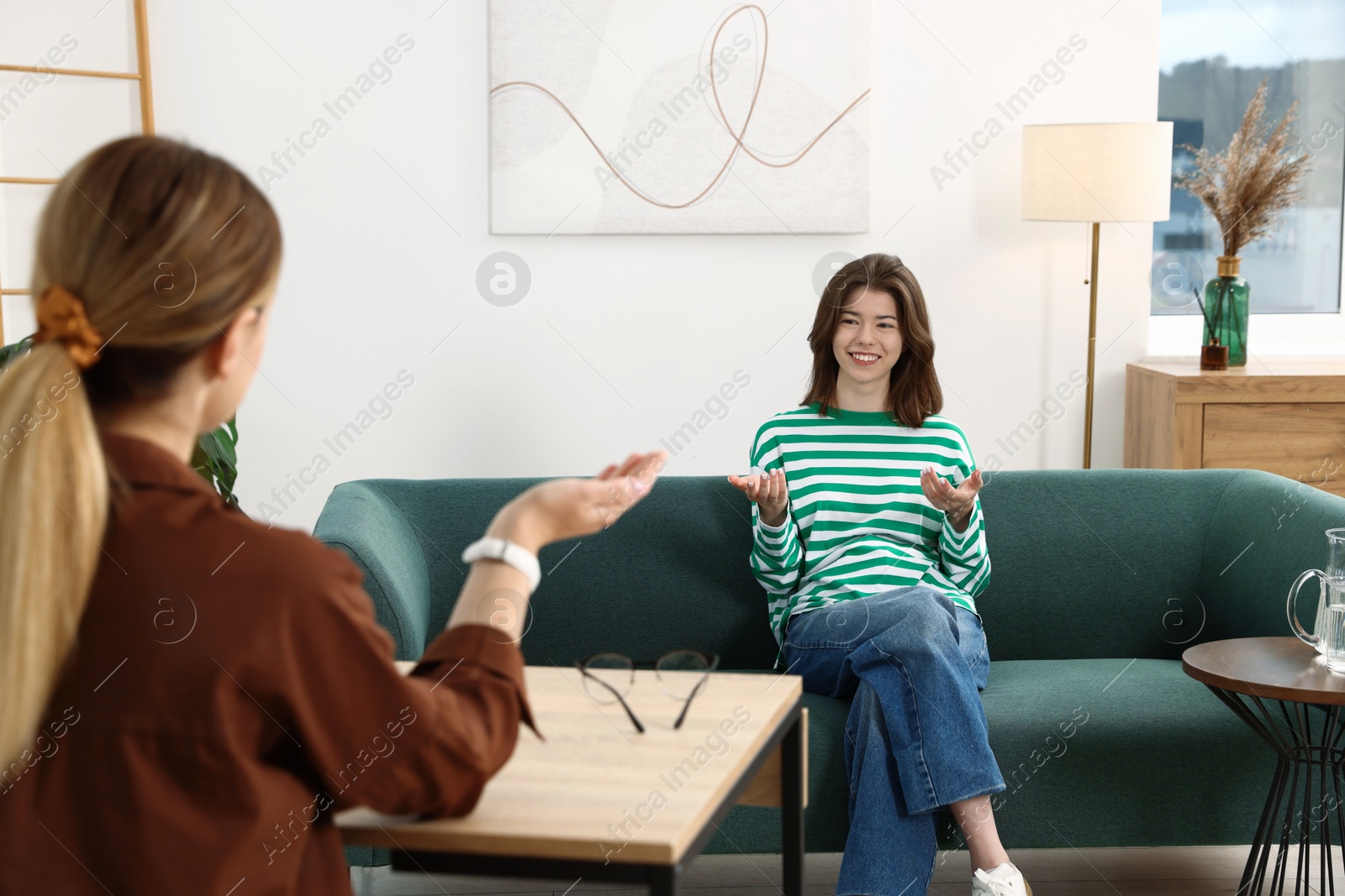 Photo of Professional psychologist working with teenage girl in office