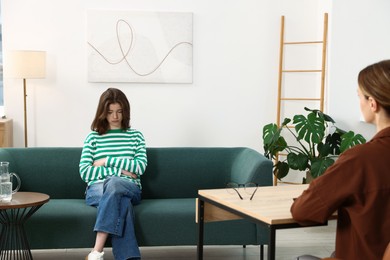 Photo of Professional psychologist working with teenage girl in office
