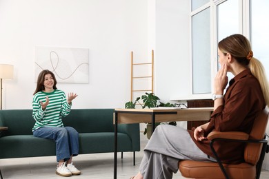 Photo of Professional psychologist working with teenage girl in office
