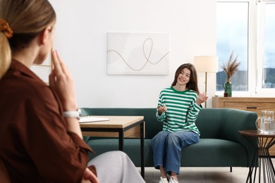 Photo of Professional psychologist working with teenage girl in office, selective focus