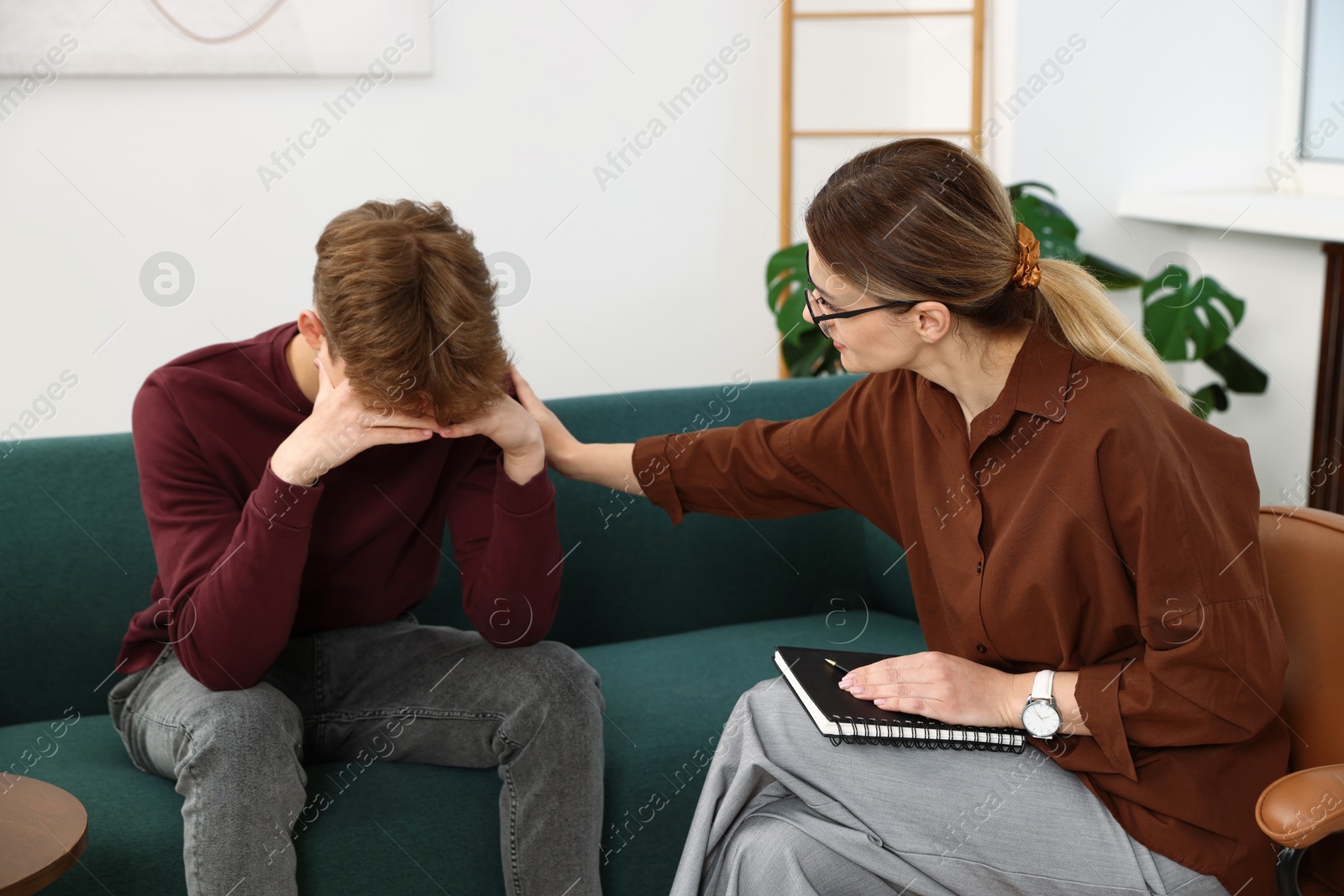Photo of Professional psychologist working with teenage boy in office