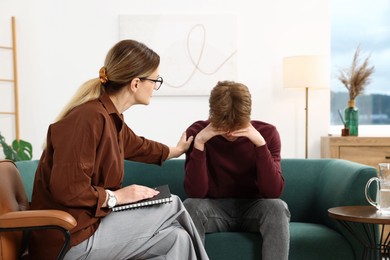 Photo of Professional psychologist working with teenage boy in office