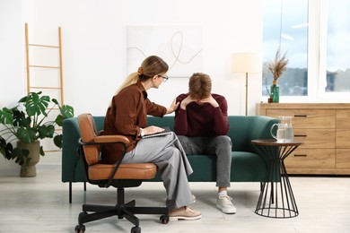 Photo of Professional psychologist working with teenage boy in office