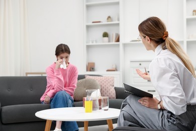 Photo of Professional psychologist working with teenage girl in office