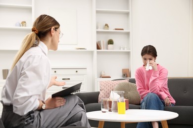 Photo of Professional psychologist working with teenage girl in office