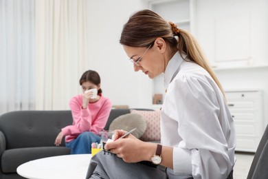 Photo of Professional psychologist working with teenage girl in office, selective focus