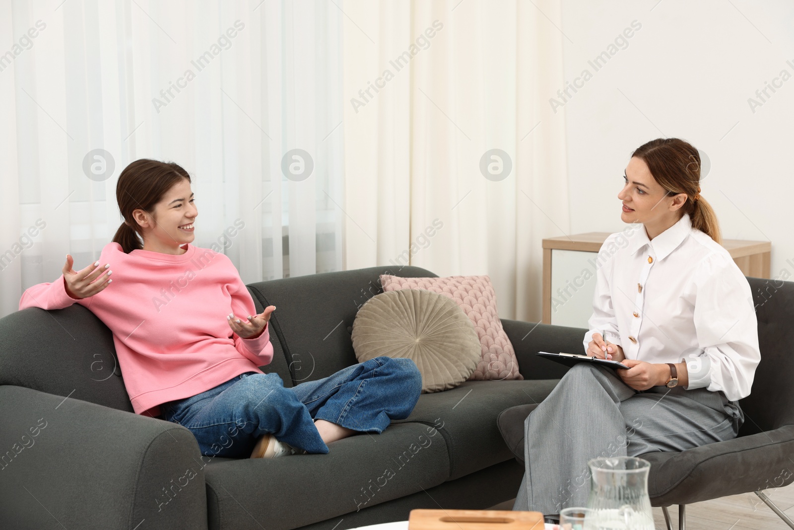Photo of Professional psychologist working with teenage girl in office