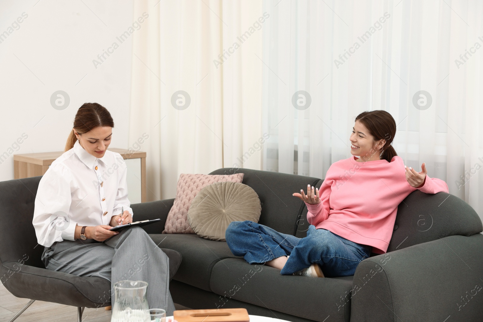Photo of Professional psychologist working with teenage girl in office