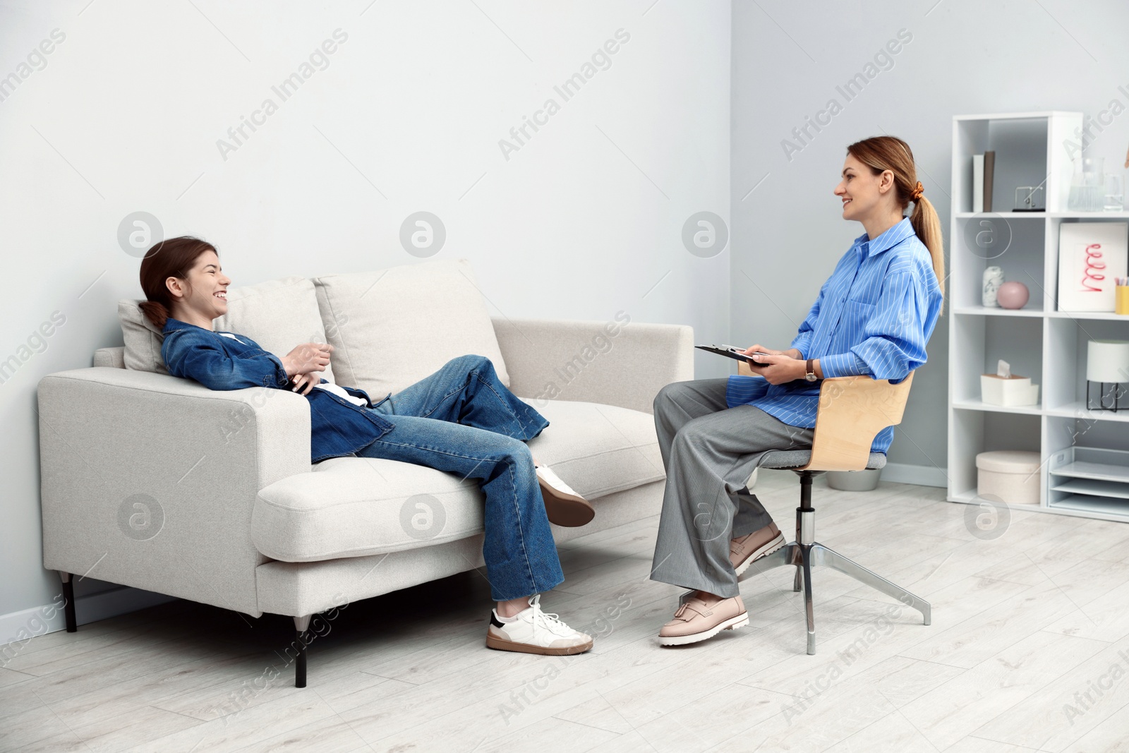 Photo of Professional psychologist working with teenage girl in office