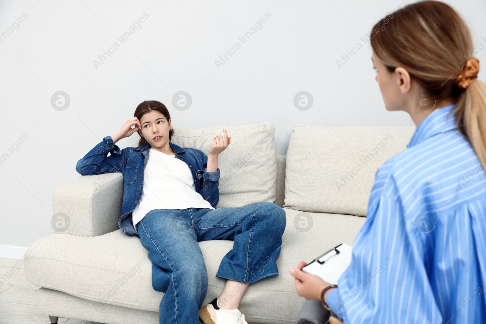 Photo of Professional psychologist working with teenage girl in office