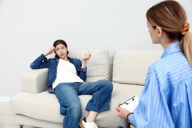 Photo of Professional psychologist working with teenage girl in office