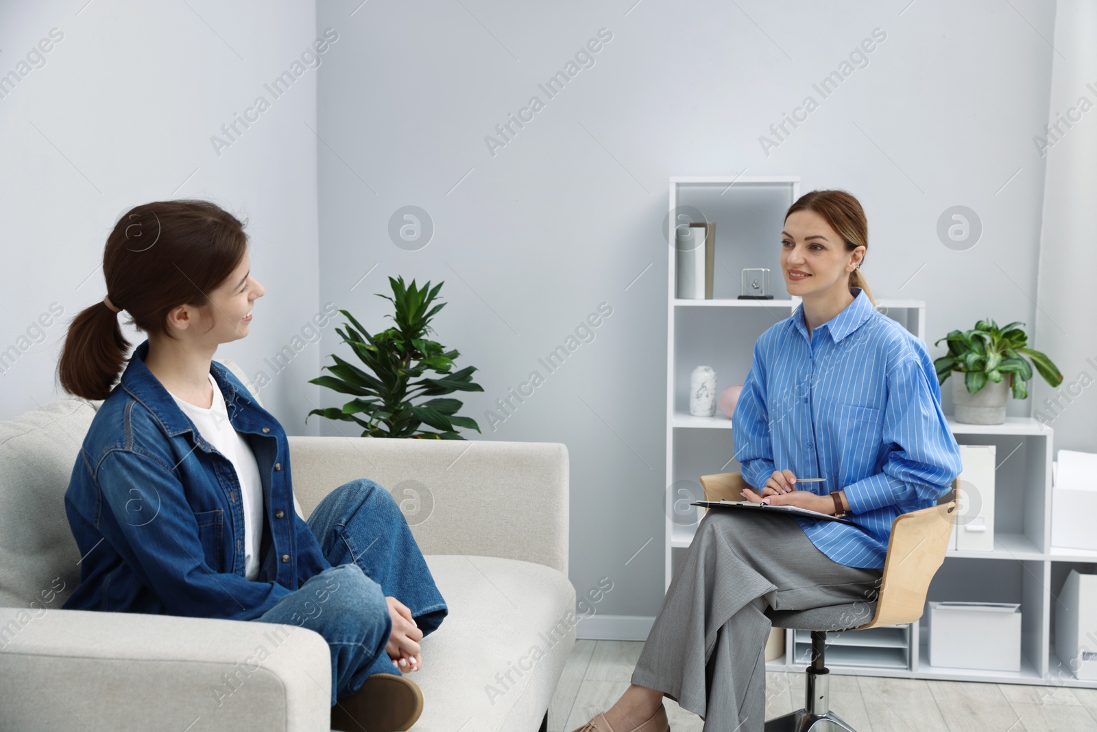 Photo of Professional psychologist working with teenage girl in office
