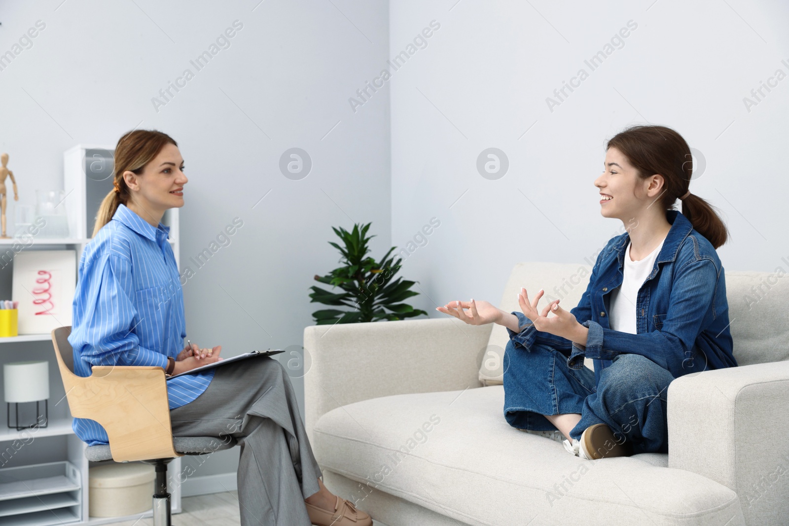 Photo of Professional psychologist working with teenage girl in office