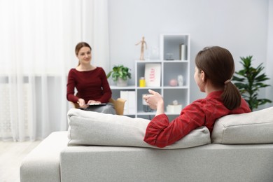 Photo of Professional psychologist working with teenage girl in office, selective focus