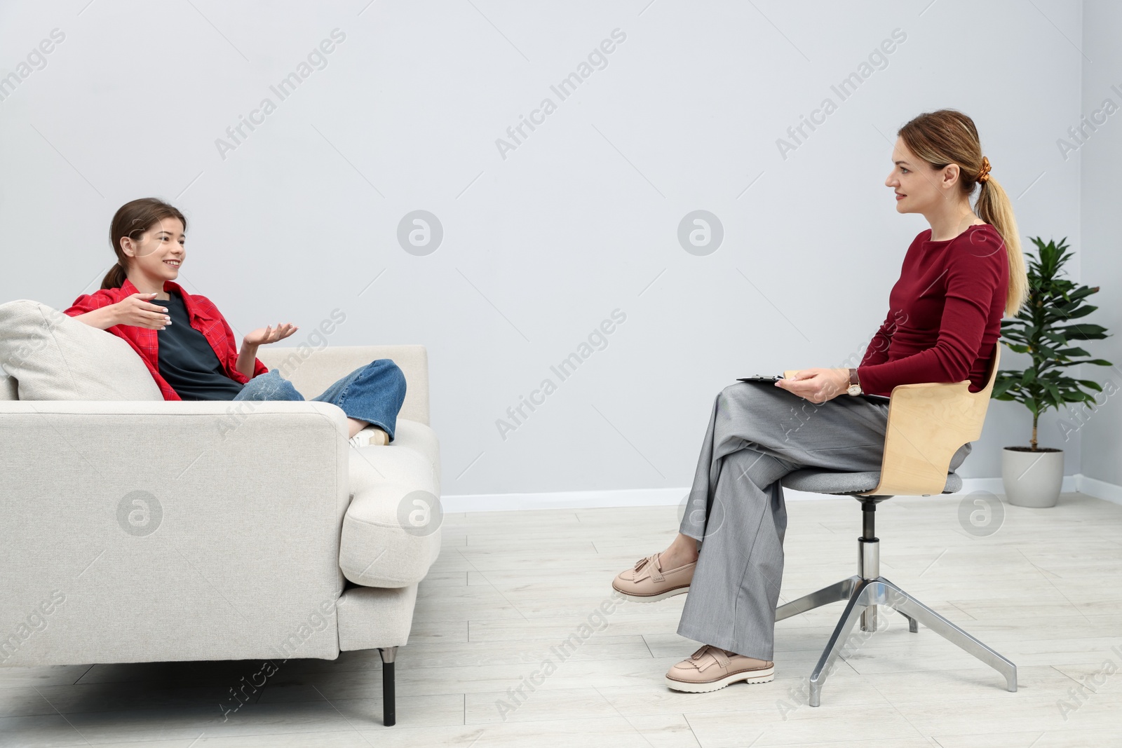 Photo of Professional psychologist working with teenage girl in office