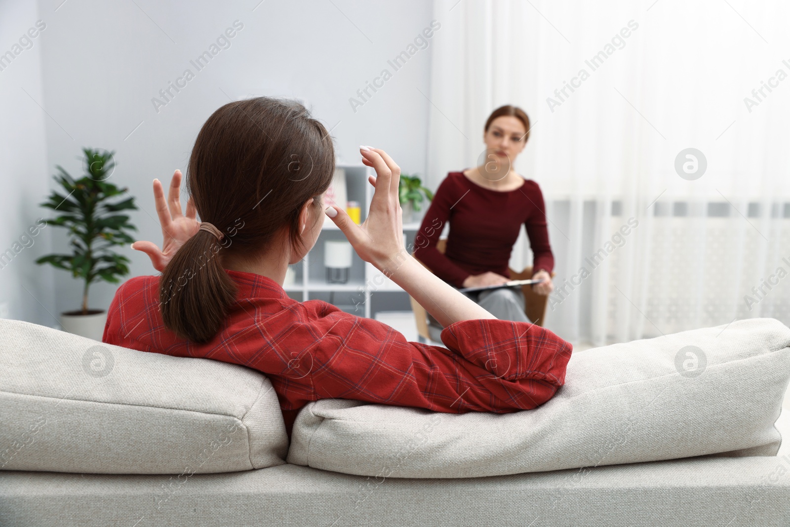 Photo of Professional psychologist working with teenage girl in office, selective focus